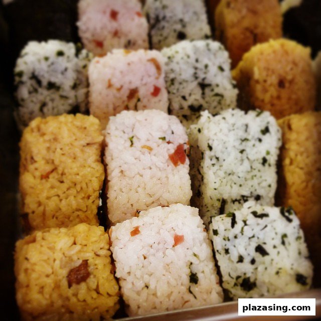 A close-up of various Japanese rice balls with different toppings and flavors.