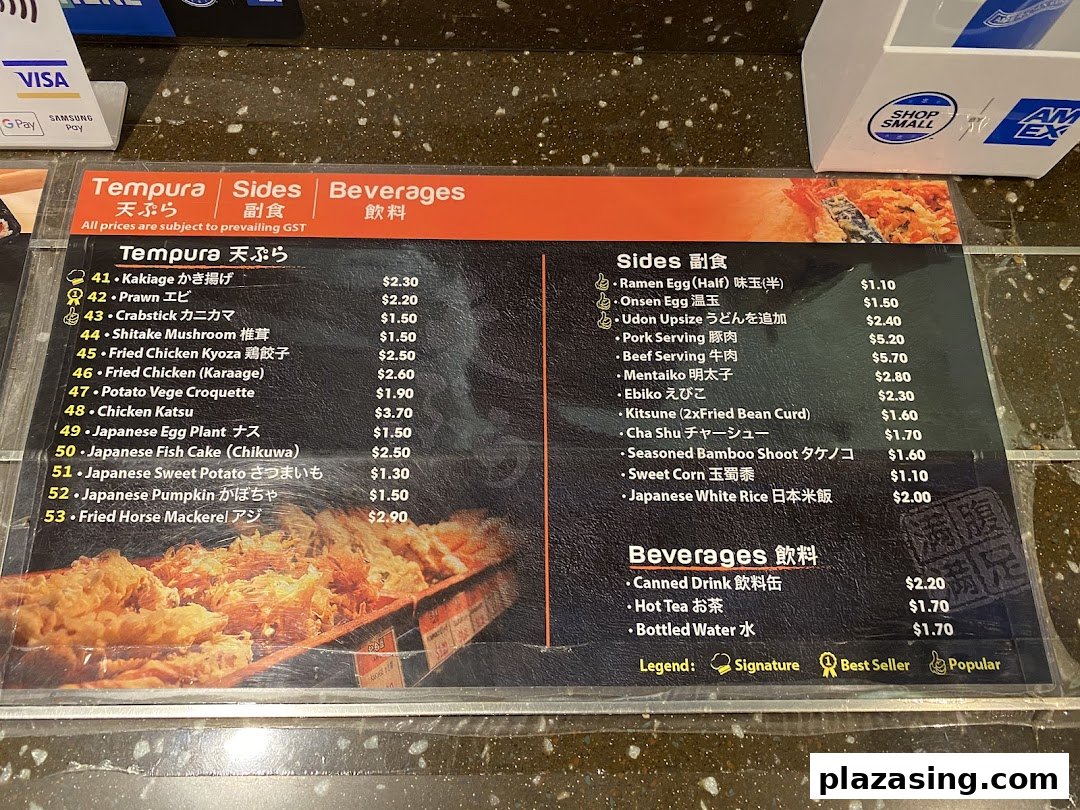 A detailed menu board displaying a variety of Japanese tempura, side dishes, and beverages with prices.