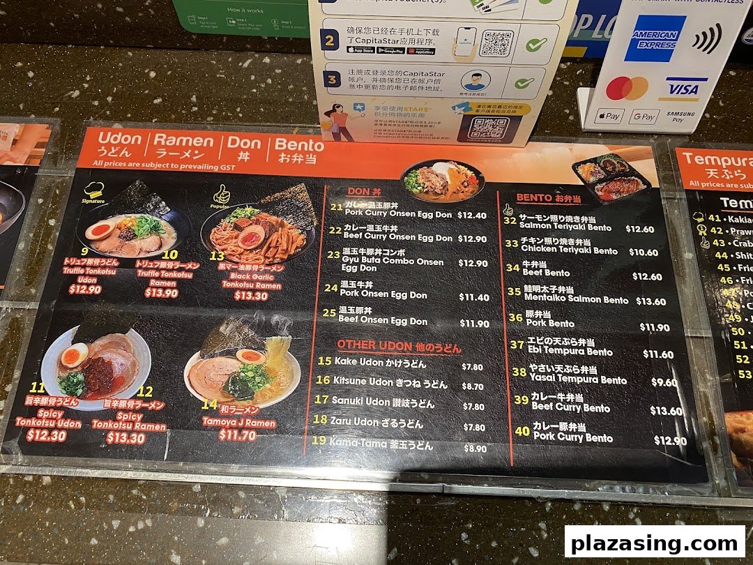 A detailed menu board displaying various Japanese dishes including Udon, Ramen, Donburi, and Bento sets with prices.