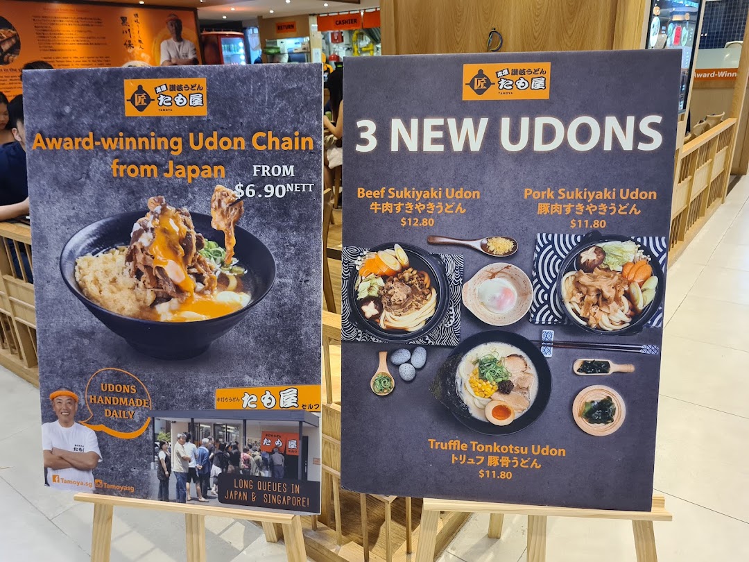 Two promotional display boards for Tamoya Udon, showcasing new dishes and general brand information.