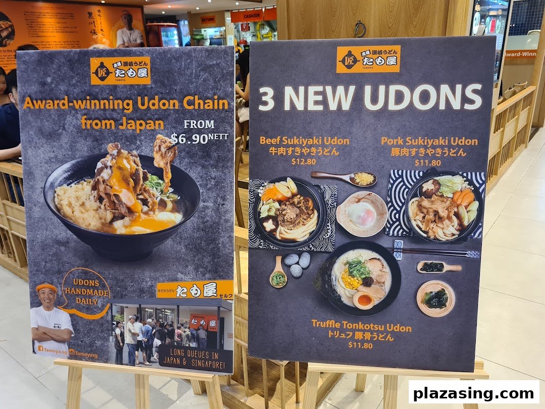 Two promotional display boards for Tamoya Udon, showcasing new dishes and general brand information.