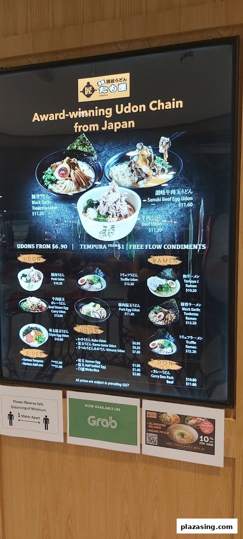 A digital menu board displaying various udon, ramen, and donburi dishes with prices and promotional information.
