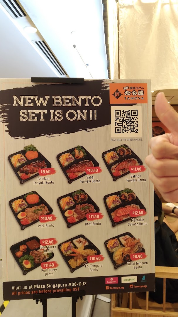 A menu board displaying Tamoya Udon's new bento sets with various Japanese dishes and prices.