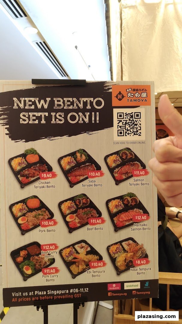A menu board displaying Tamoya Udon's new bento sets with various Japanese dishes and prices.