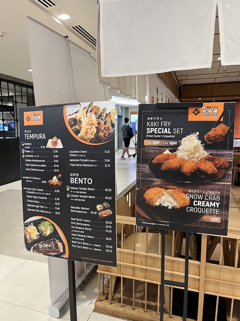 Two menu boards display Tamoya Udon's Japanese tempura, bento sets, and special fried items with prices.