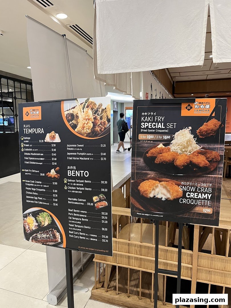 Two menu boards display Tamoya Udon's Japanese tempura, bento sets, and special fried items with prices.