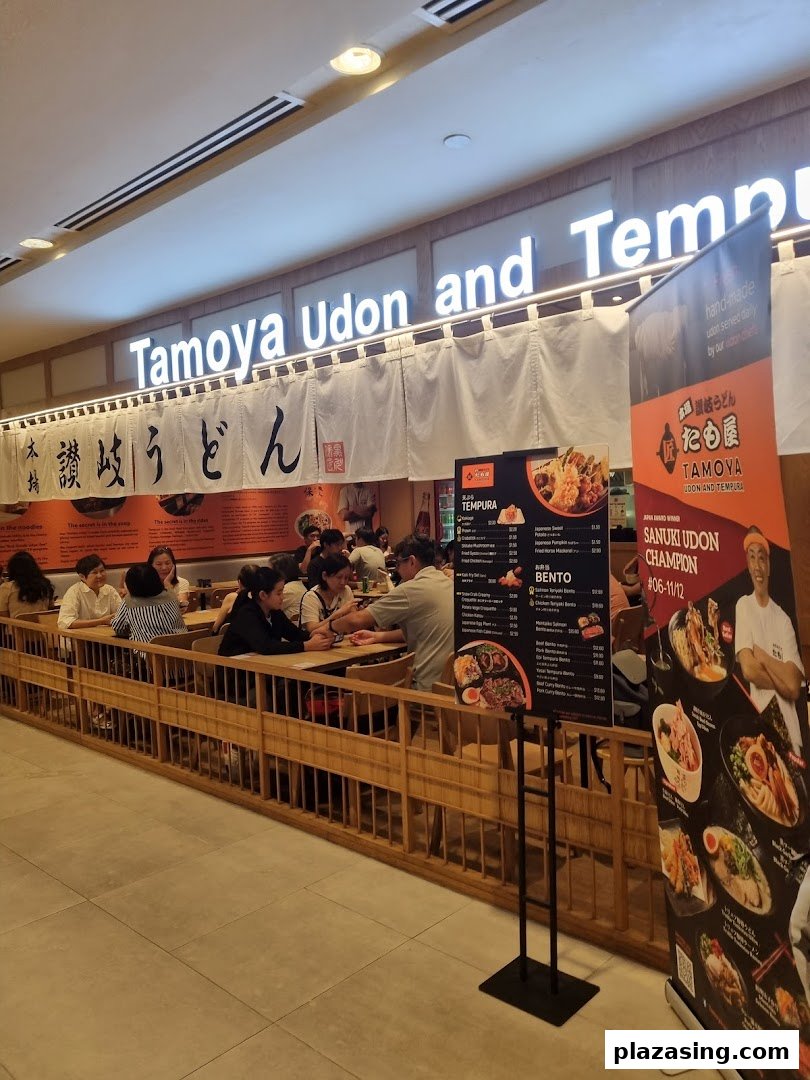 Customers enjoy authentic Japanese udon and tempura in a bustling restaurant interior.