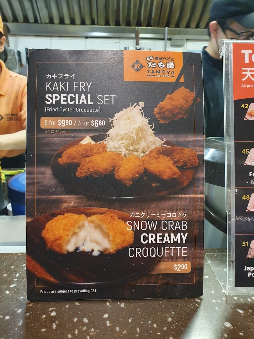 A menu board displaying Kaki Fry Special Set and Snow Crab Creamy Croquette at Tamoya Udon & Tempura.