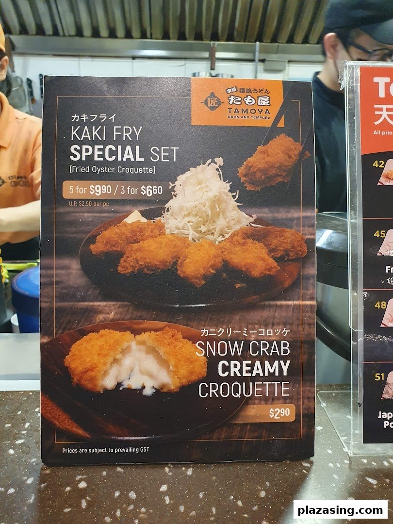 A menu board displaying Kaki Fry Special Set and Snow Crab Creamy Croquette at Tamoya Udon & Tempura.