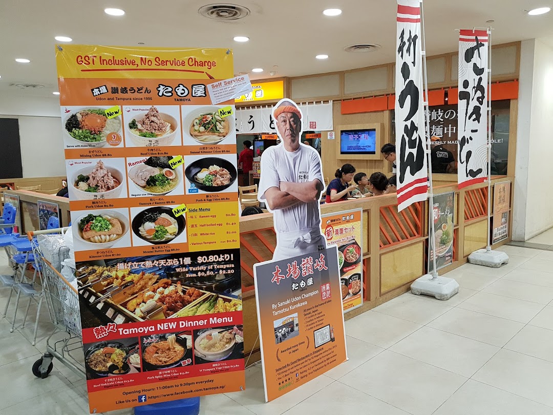 A promotional display for Tamoya Udon & Tempura, featuring a menu banner, chef standee, and shop entrance.