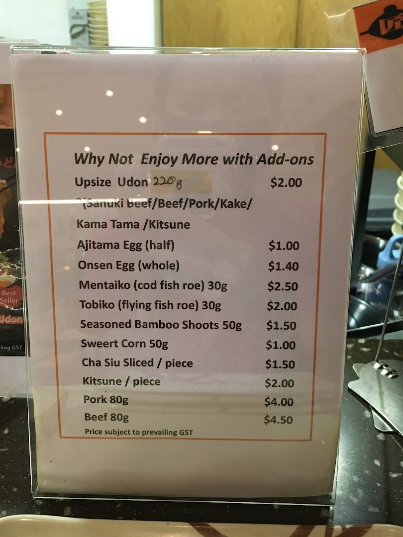 A menu board displaying various add-ons and their prices for udon dishes.