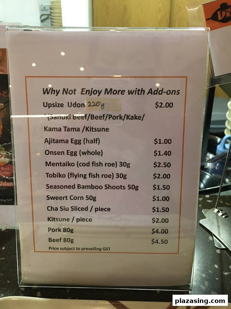 A menu board displaying various add-ons and their prices for udon dishes.