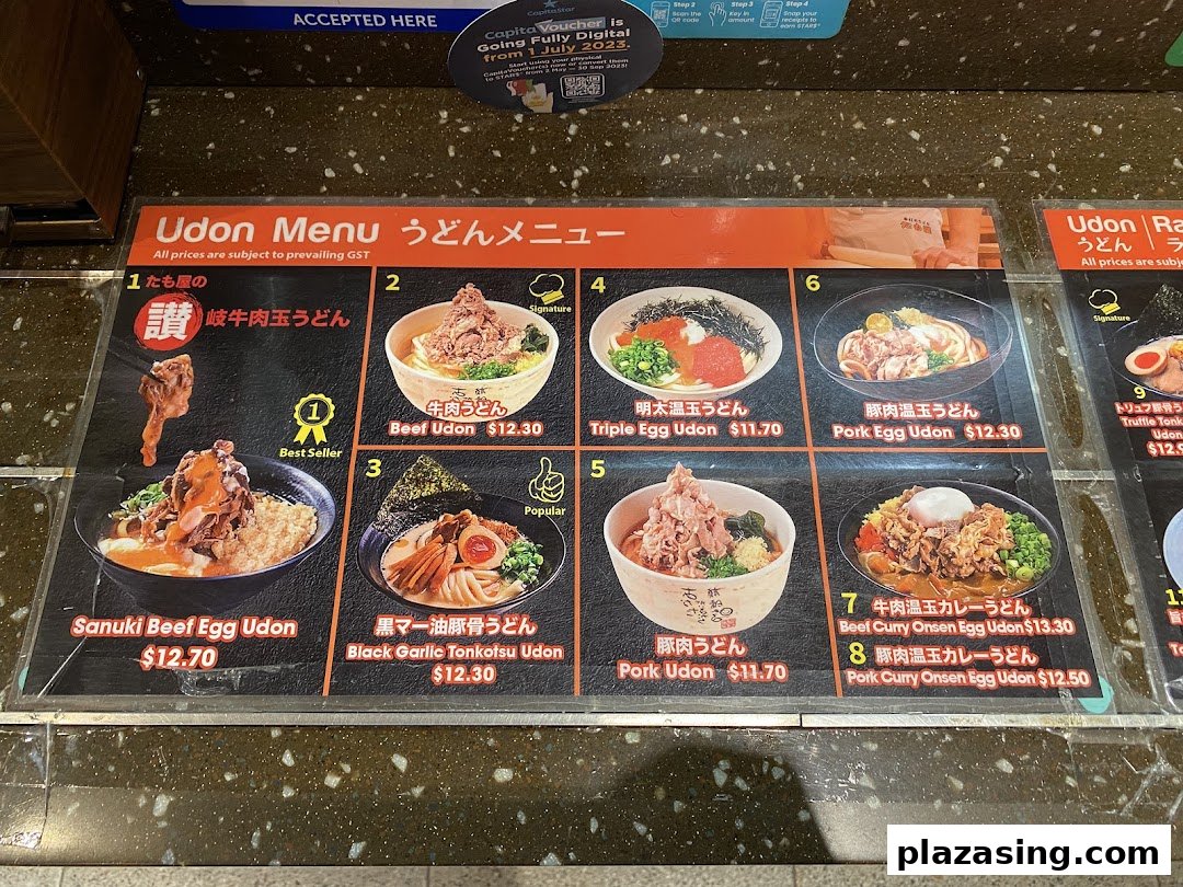 A detailed menu board displaying various udon and ramen dishes with prices and images.