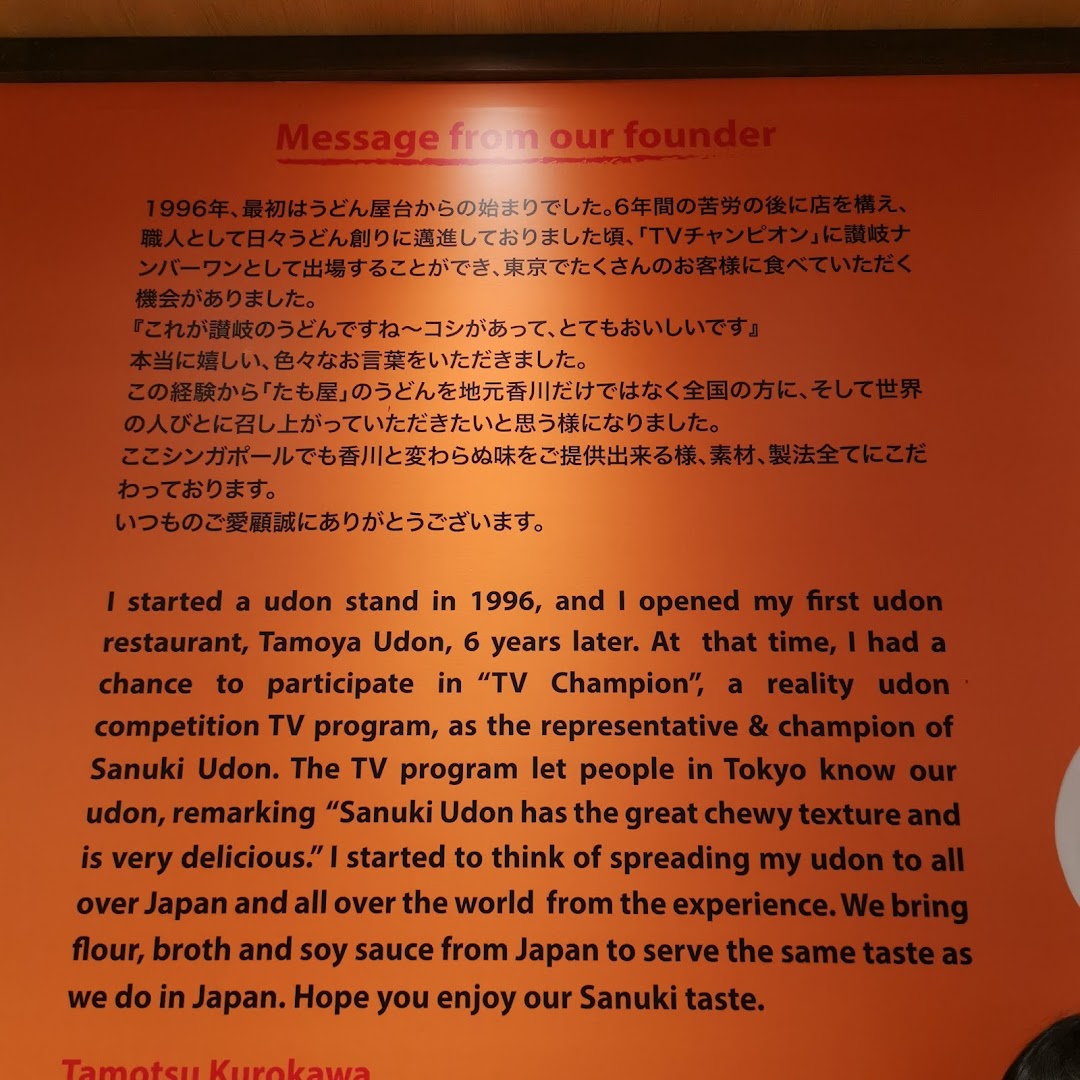 A wall display featuring a message from Tamoya Udon's founder, detailing the brand's history and commitment to authentic taste.