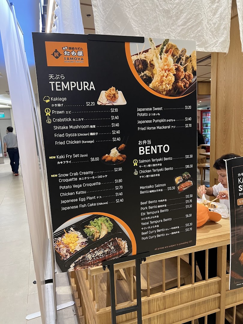 A menu board for Tamoya Udon & Tempura, showcasing various tempura and bento options with prices.
