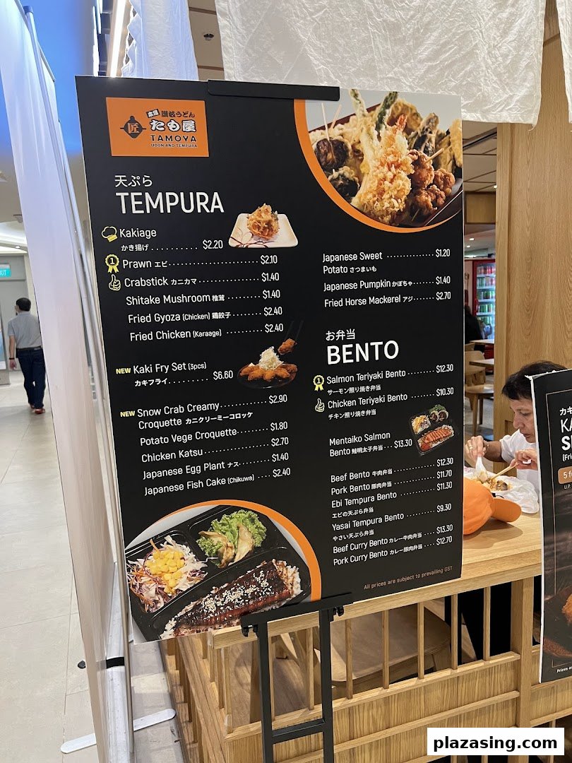 A menu board for Tamoya Udon & Tempura, showcasing various tempura and bento options with prices.