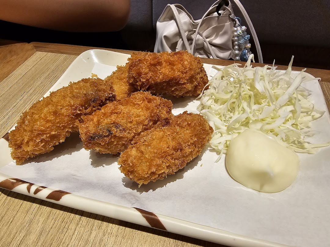 A plate of golden-fried tempura or katsu items with shredded cabbage and mayonnaise.
