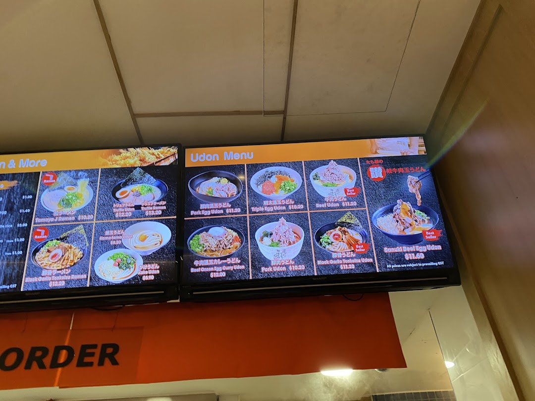 Digital menu boards displaying a variety of Japanese udon and ramen dishes with prices.