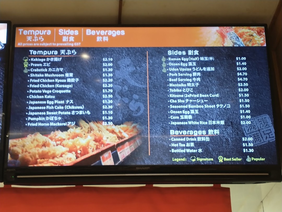 A digital menu board displaying a variety of tempura, sides, and beverages with prices at Tamoya Udon.