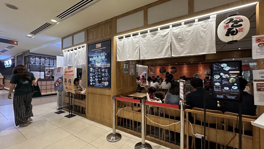 A bustling interior view of Tamoya Udon & Tempura, showcasing its inviting ambiance and diners enjoying authentic Japanese cuisine.