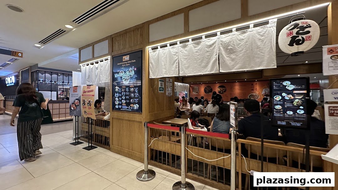A bustling interior view of Tamoya Udon & Tempura, showcasing its inviting ambiance and diners enjoying authentic Japanese cuisine.