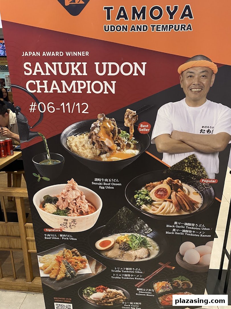 A promotional display board for Tamoya Udon & Tempura, showcasing award-winning udon dishes and other Japanese specialties.