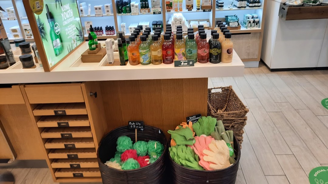 An interior view of The Body Shop, showcasing a counter with various body care products and bath accessories.