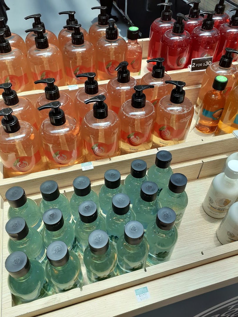 A vibrant display of The Body Shop's bath and body products, including large pump bottles and smaller items.