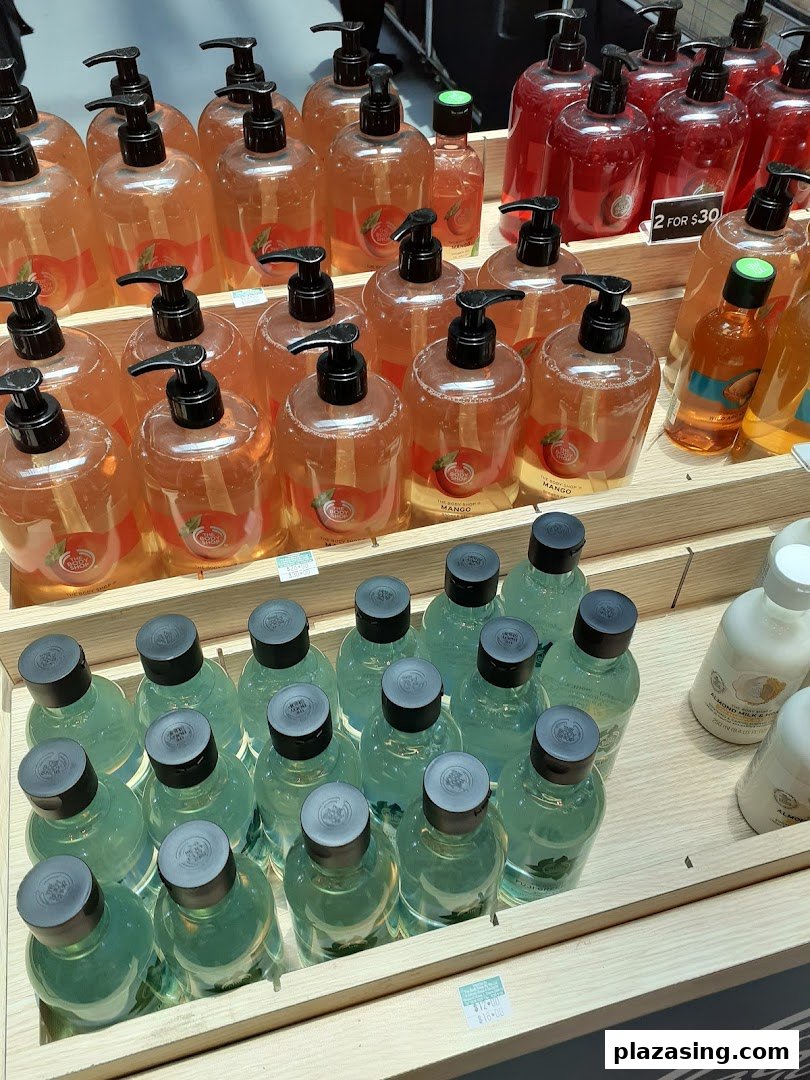 A vibrant display of The Body Shop's bath and body products, including large pump bottles and smaller items.