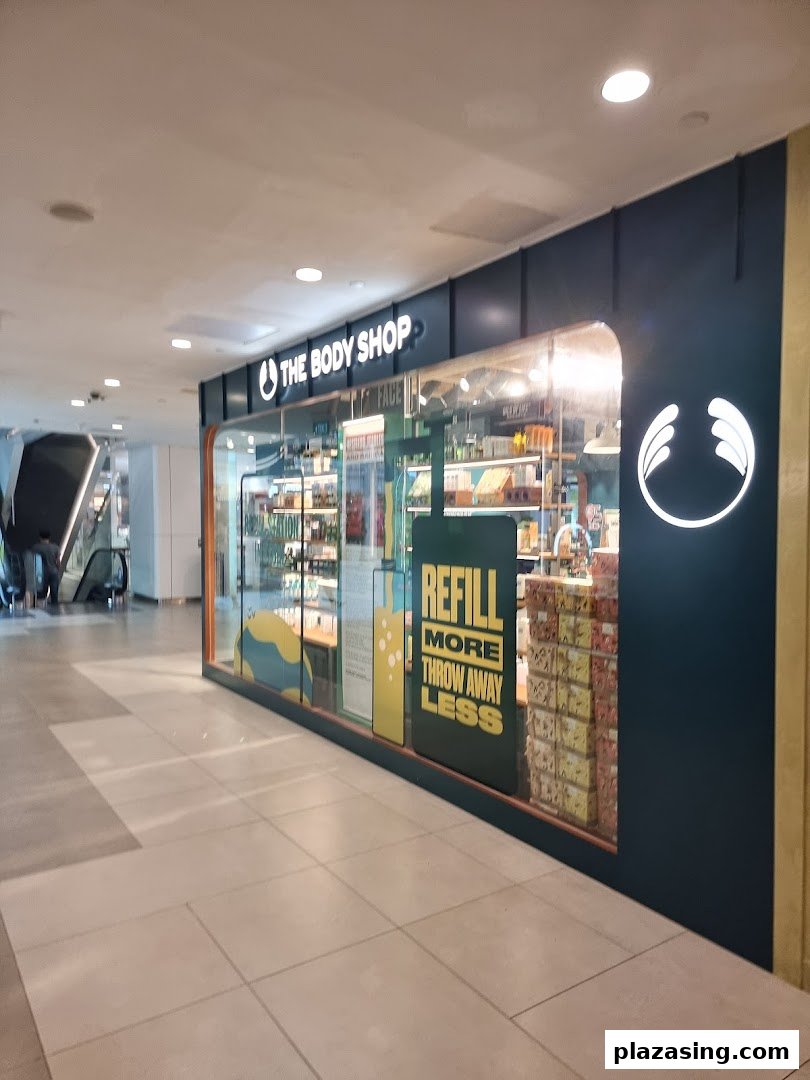 The Body Shop storefront featuring its logo, products, and a 'Refill More Throw Away Less' sign.
