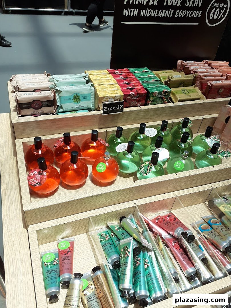 A display of The Body Shop's body care products, including soaps, lotions, and fragrances, with a '2 for $12' offer.