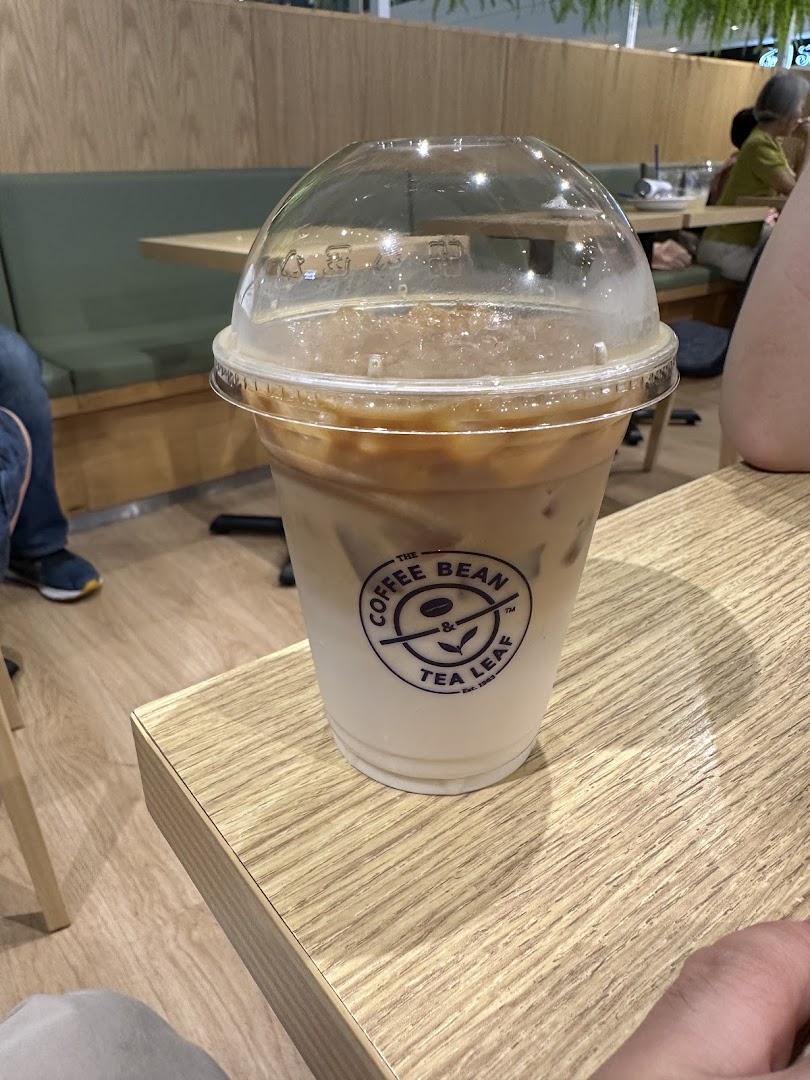 An iced coffee drink from The Coffee Bean & Tea Leaf on a wooden table inside the cafe.