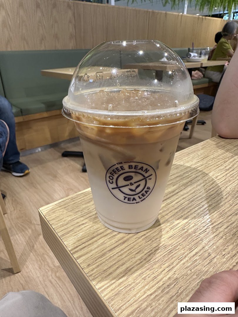 An iced coffee drink from The Coffee Bean & Tea Leaf on a wooden table inside the cafe.