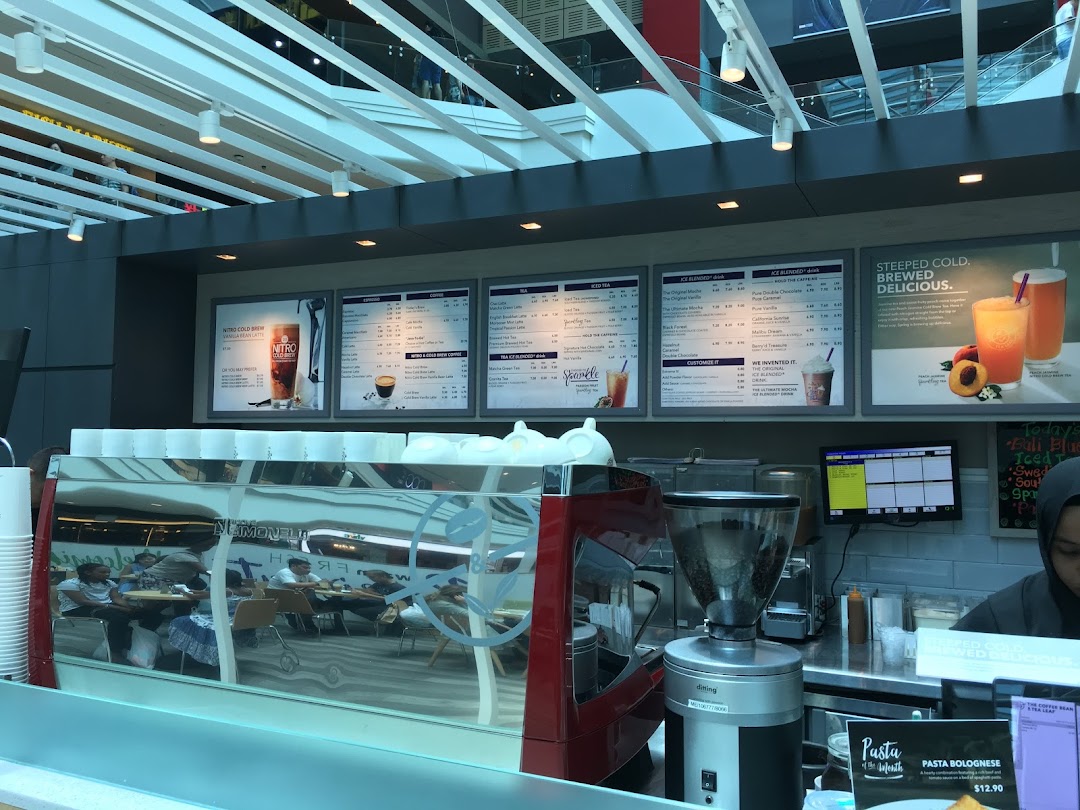 The counter area of The Coffee Bean & Tea Leaf, featuring prominent menu boards and a coffee machine.