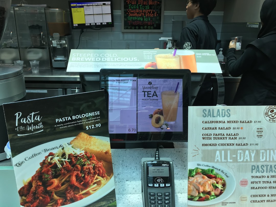 A bustling counter at The Coffee Bean & Tea Leaf, showcasing various menu items and staff.