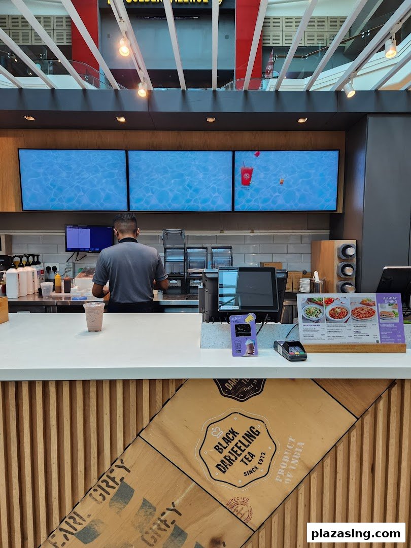 Interior view of The Coffee Bean & Tea Leaf counter with staff and digital displays.