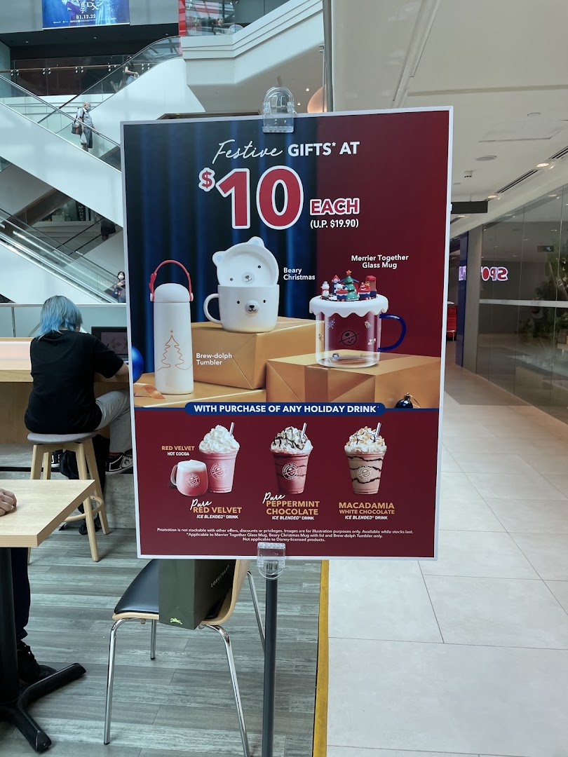 A promotional stand displaying festive gifts and holiday drinks from The Coffee Bean & Tea Leaf.