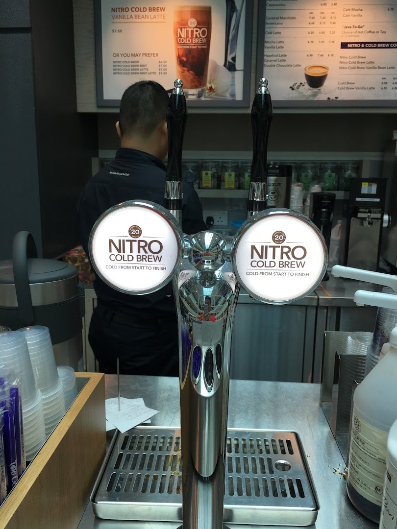 Interior view of The Coffee Bean & Tea Leaf counter featuring nitro cold brew taps and menu boards.