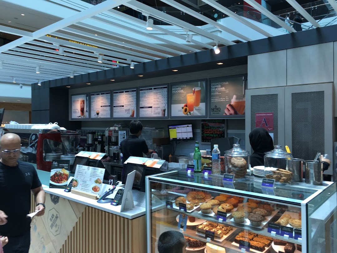 Interior view of The Coffee Bean & Tea Leaf, featuring the service counter, display case, and staff.