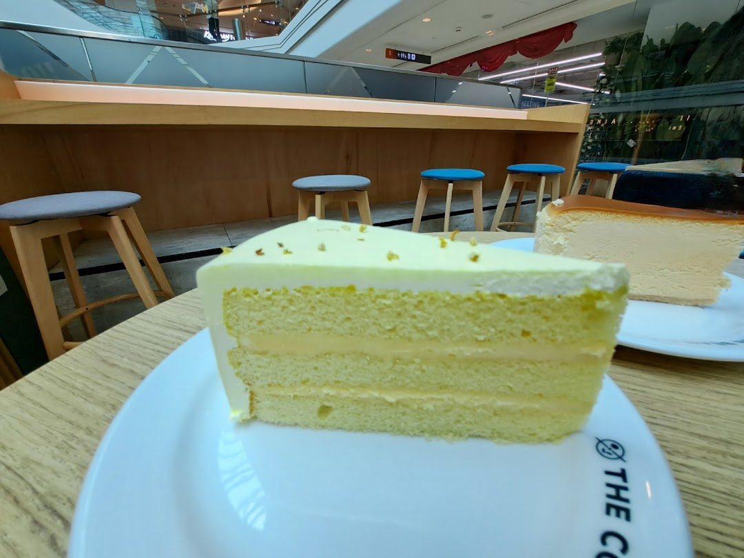 A close-up of delicious cakes on a table inside The Coffee Bean & Tea Leaf, with seating in the background.