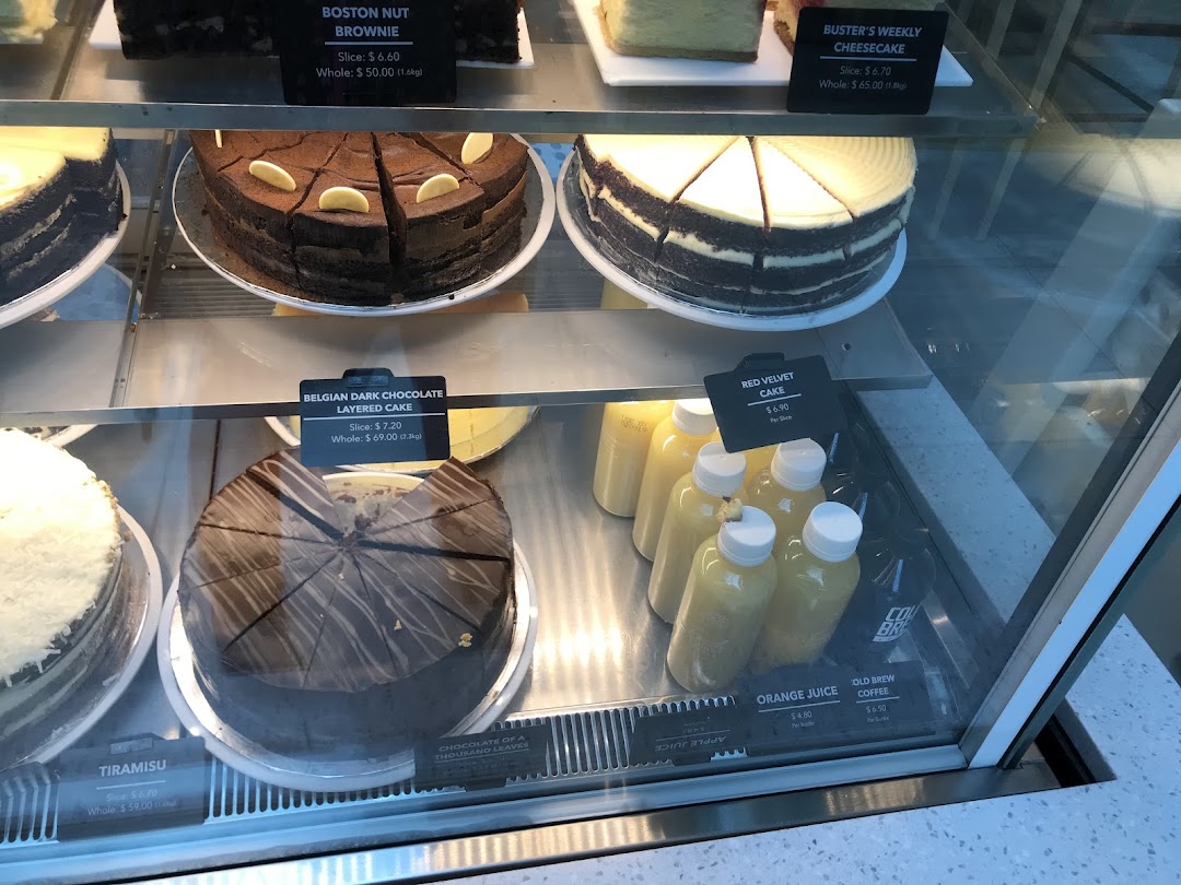 A display case showcasing various cakes and bottled beverages at The Coffee Bean & Tea Leaf.