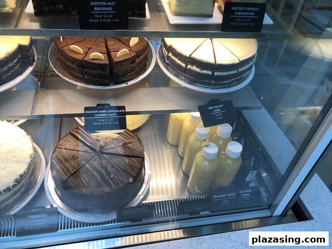 A display case showcasing various cakes and bottled beverages at The Coffee Bean & Tea Leaf.