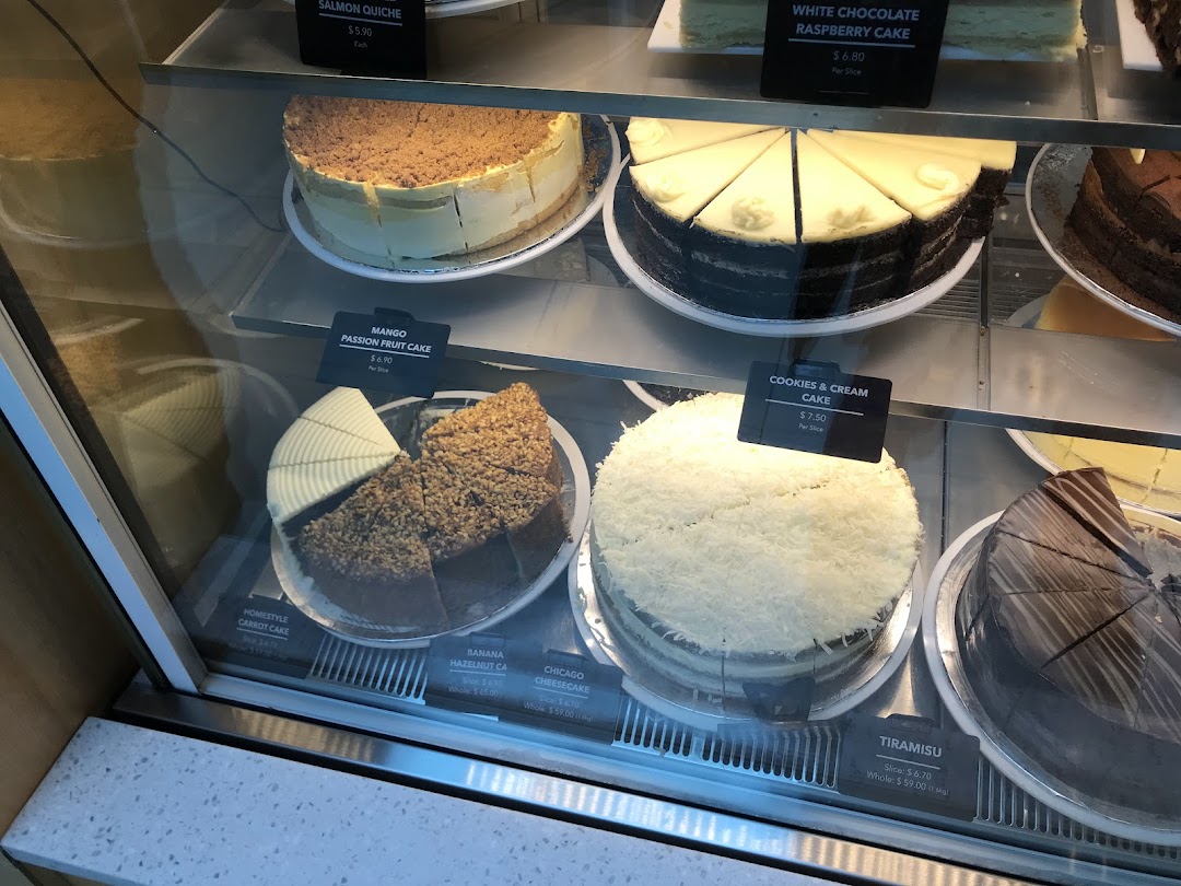 A vibrant display case showcasing a variety of delicious cakes and pastries at The Coffee Bean & Tea Leaf.