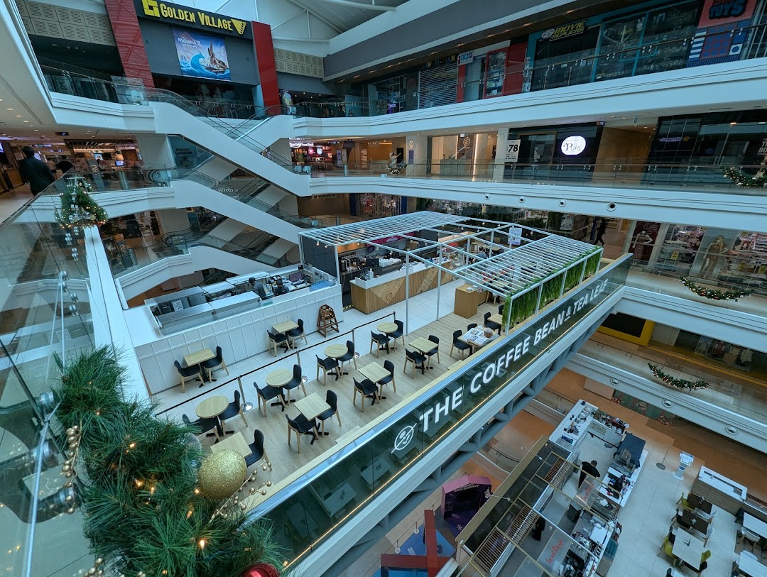 An aerial view of The Coffee Bean & Tea Leaf cafe within a bustling multi-story shopping mall.