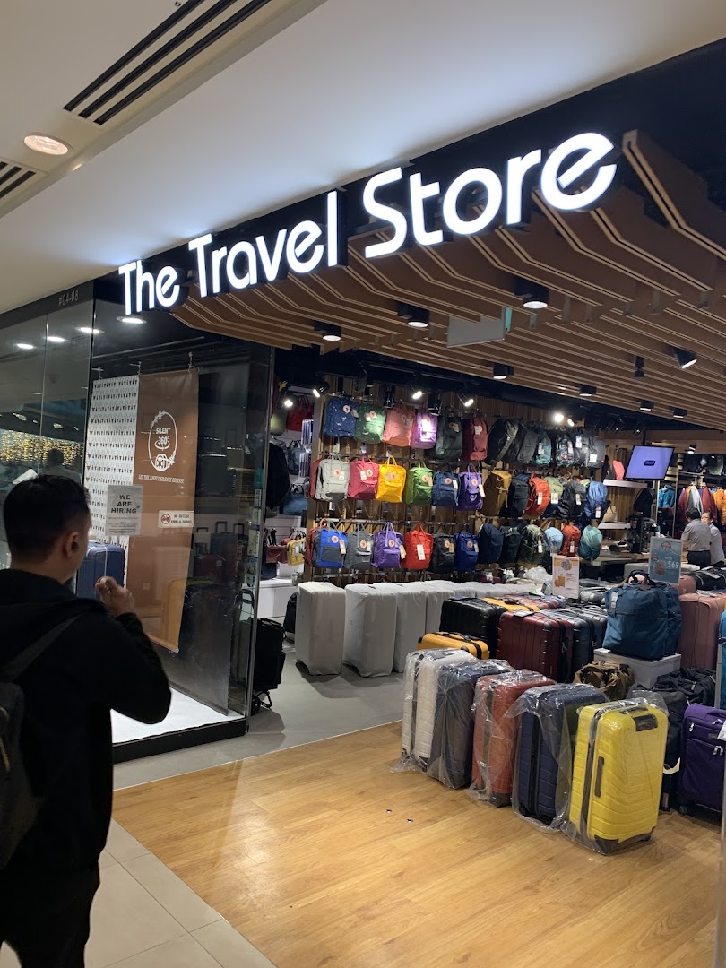 The shop front of 'The Travel Store' showcasing a wide array of colorful backpacks and luggage.