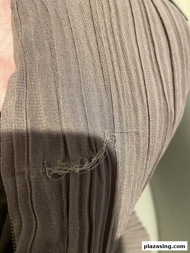 Close-up of a pleated fabric garment, highlighting its texture and detail.