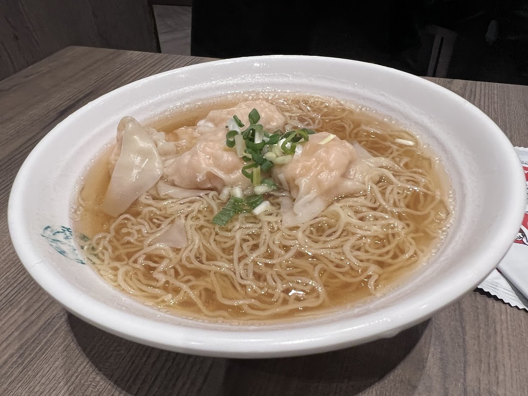 A close-up of a delicious bowl of wonton noodles with broth and green onions from Tim Ho Wan.