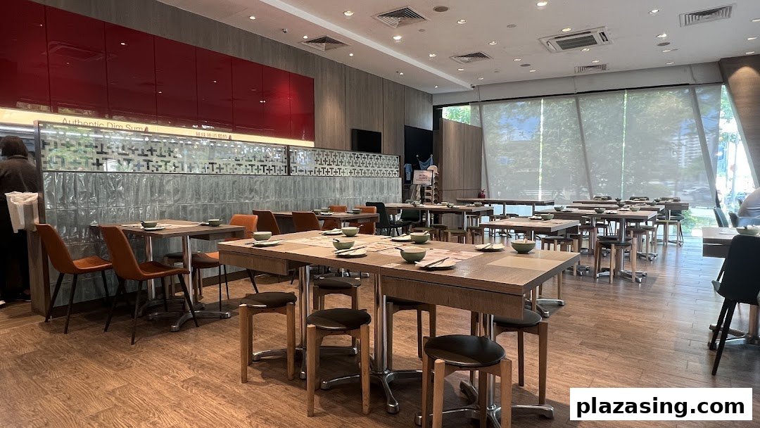 Spacious and modern dining area of Tim Ho Wan, set with tables and chairs for guests.