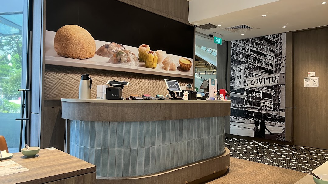 Interior view of Tim Ho Wan featuring the service counter, dim sum display, and Hong Kong-inspired decor.
