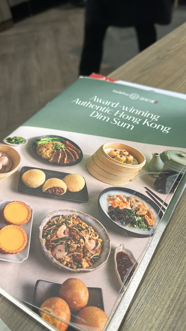 A close-up view of the Tim Ho Wan menu cover, showcasing various authentic Hong Kong dim sum dishes.